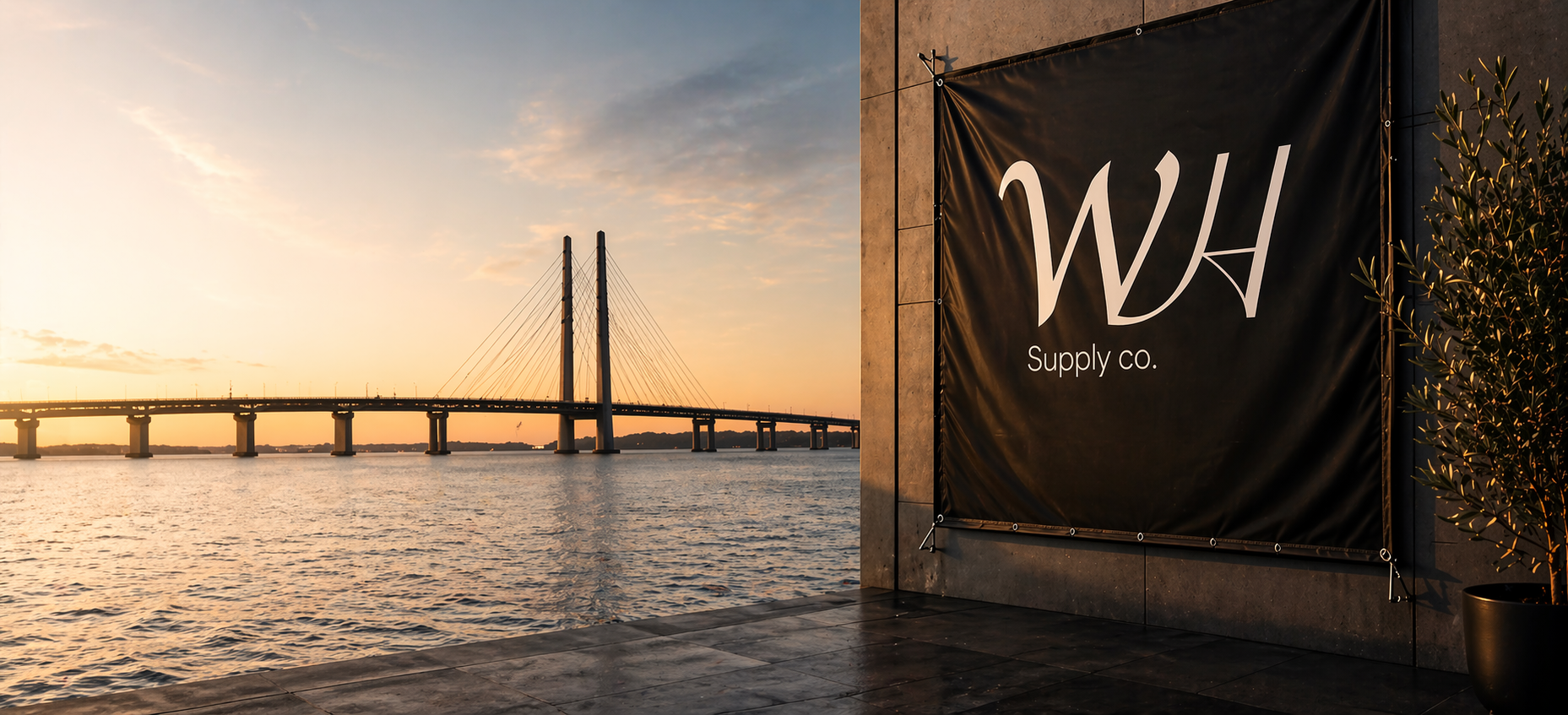 Banderoll med WH Supply Co logotyp vid Öresundsbron i Malmö under solnedgång