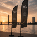 Svarta beachflaggor med stilren design och WH Supply-logga uppställda utomhus vid event.