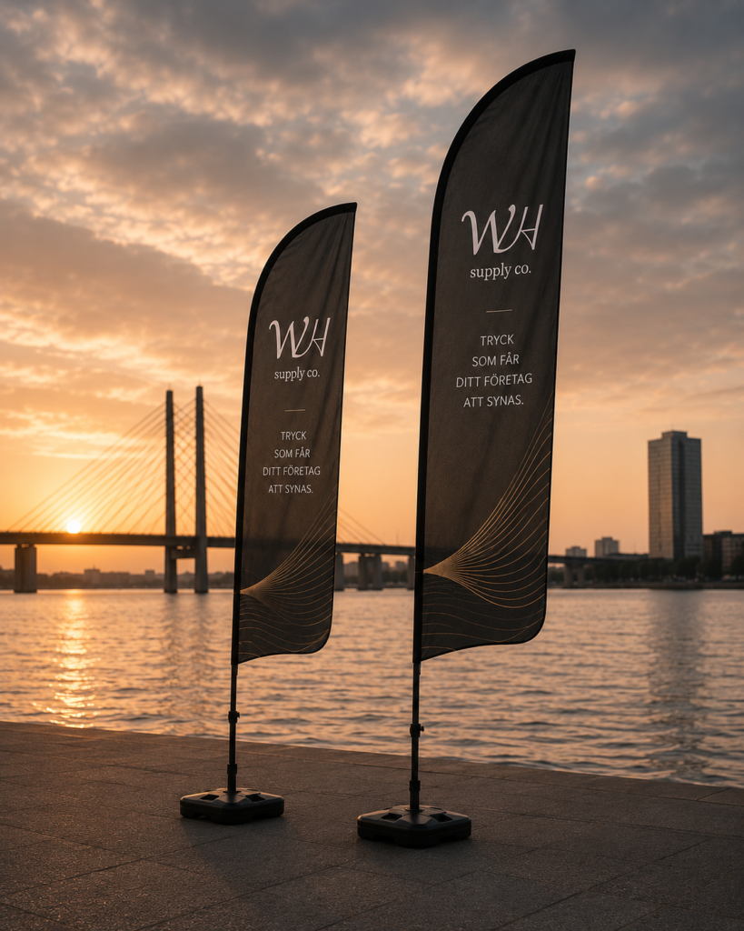 Svarta beachflaggor med stilren design och WH Supply-logga uppställda utomhus vid event.